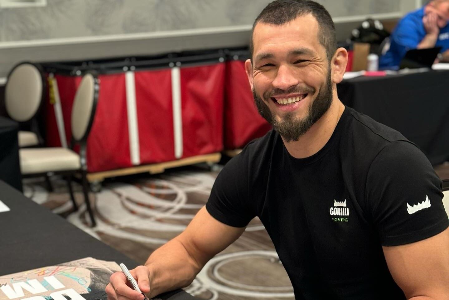 Machmud Muradov při podepisování plakátů v UFC.