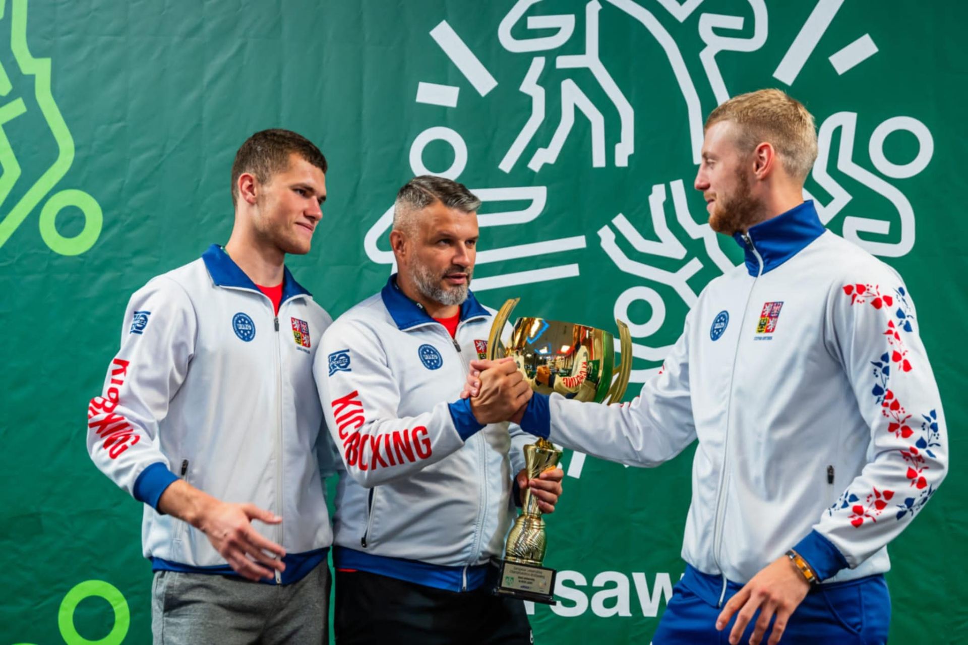 Čeští kickboxeři slaví spolu s trenérem Kamilem Šamalem. 
